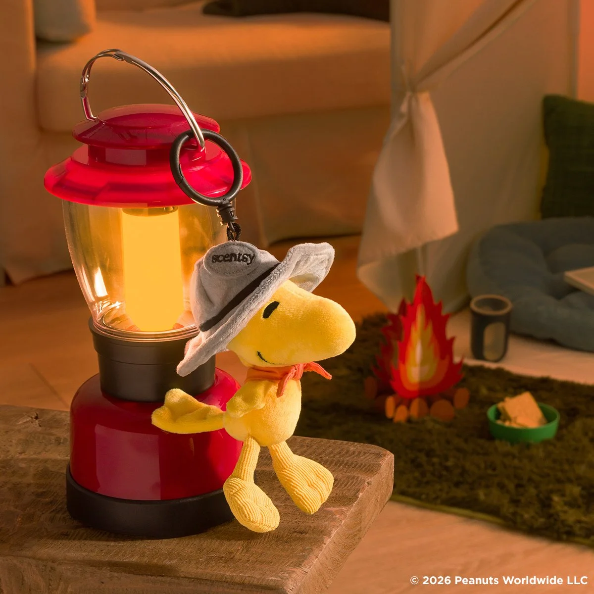 Woodstock Beagle Scouts Scentsy Buddy Clip hanging from a lantern beside a campsite scene with a campfire, inspired by the Peanuts Beagle Scouts adventure theme