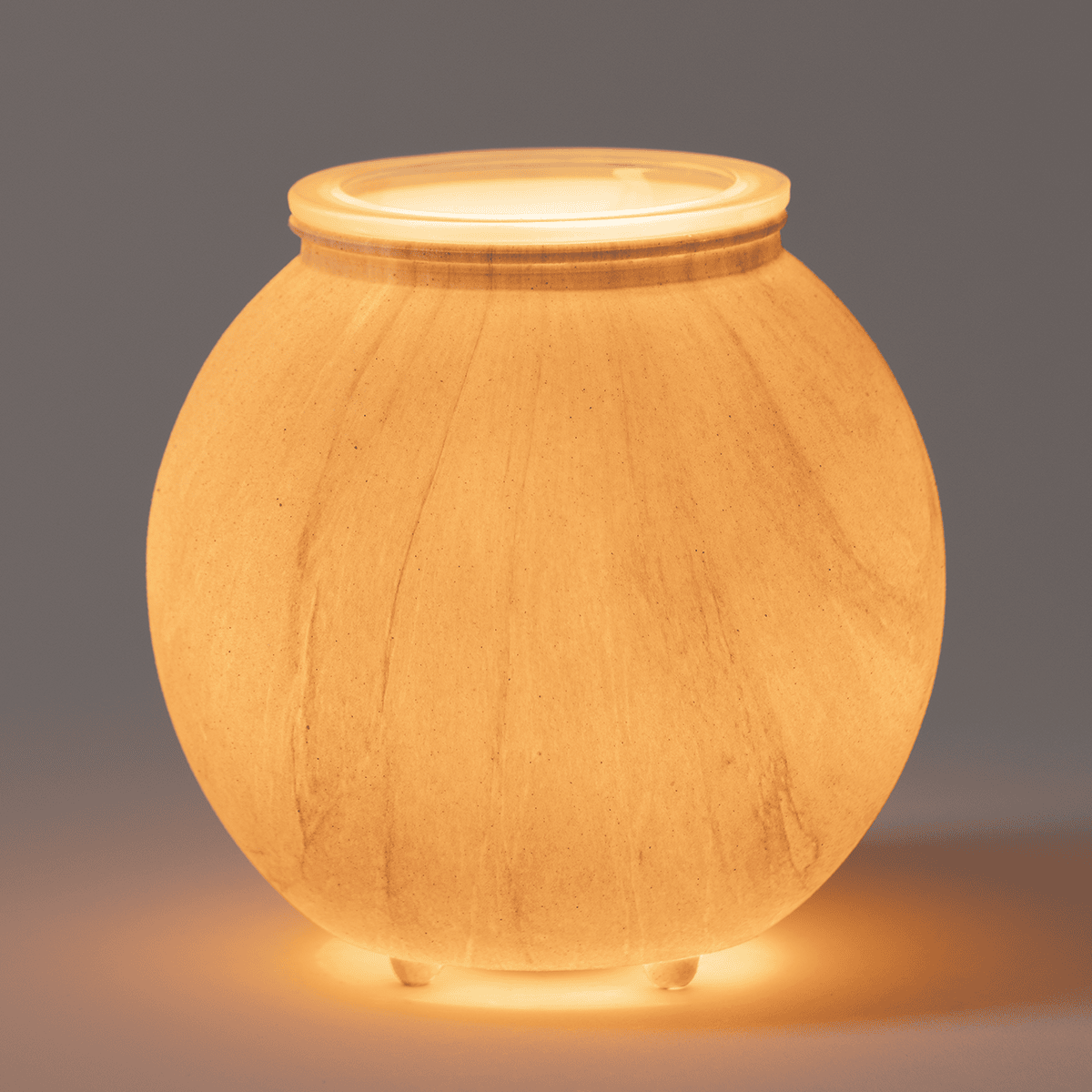 Sanded Linea Scentsy warmer glowing in dark room showing warm ambient full-body light