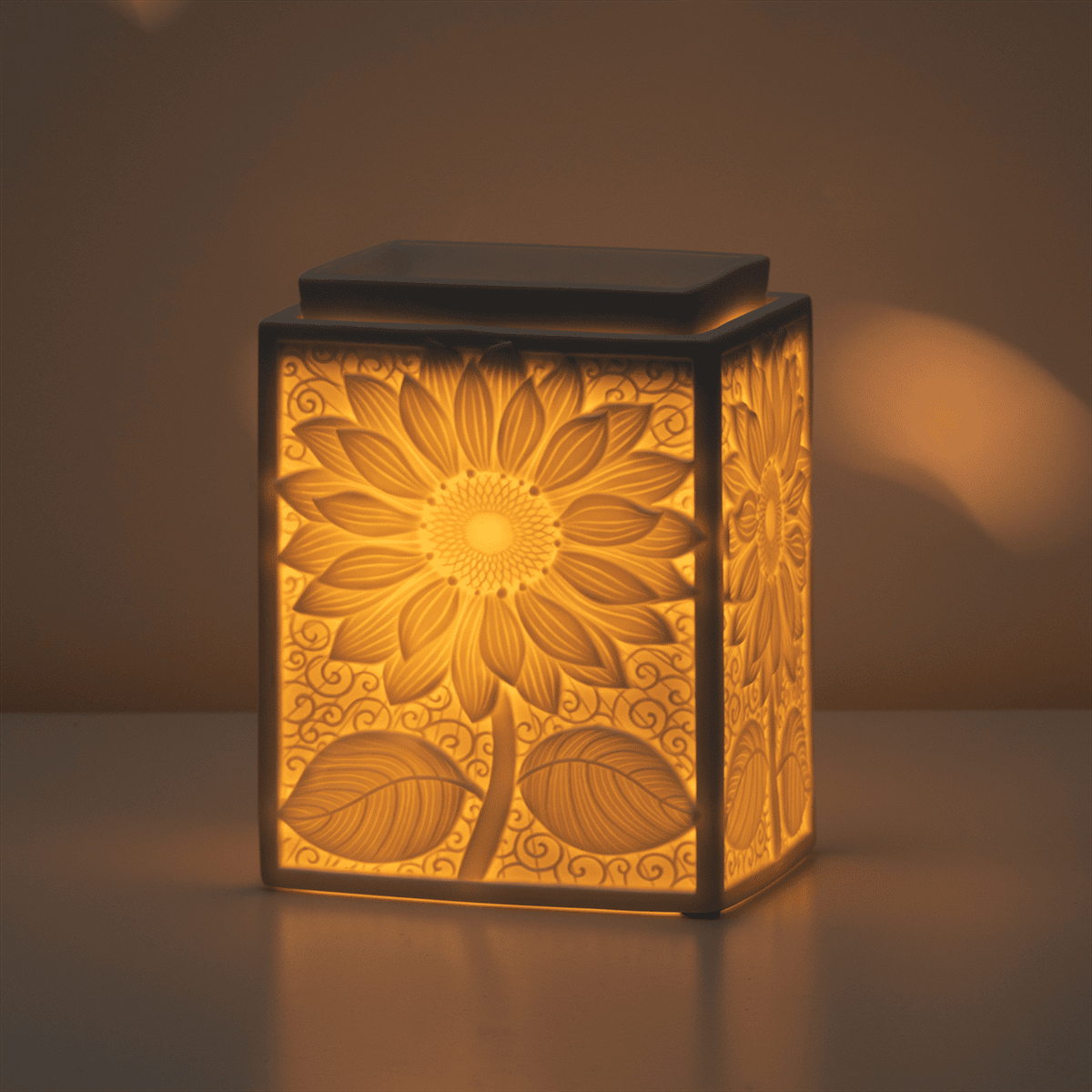 Sunburst Scentsy Warmer styled in a dark room glowing and showing the shine
