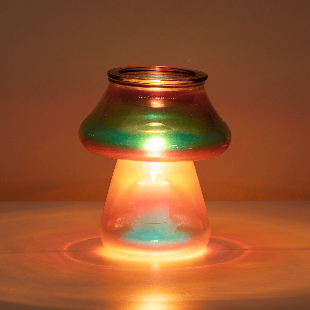 Amanita Scentsy Warmer glowing in a dark room with vibrant multicoloured light