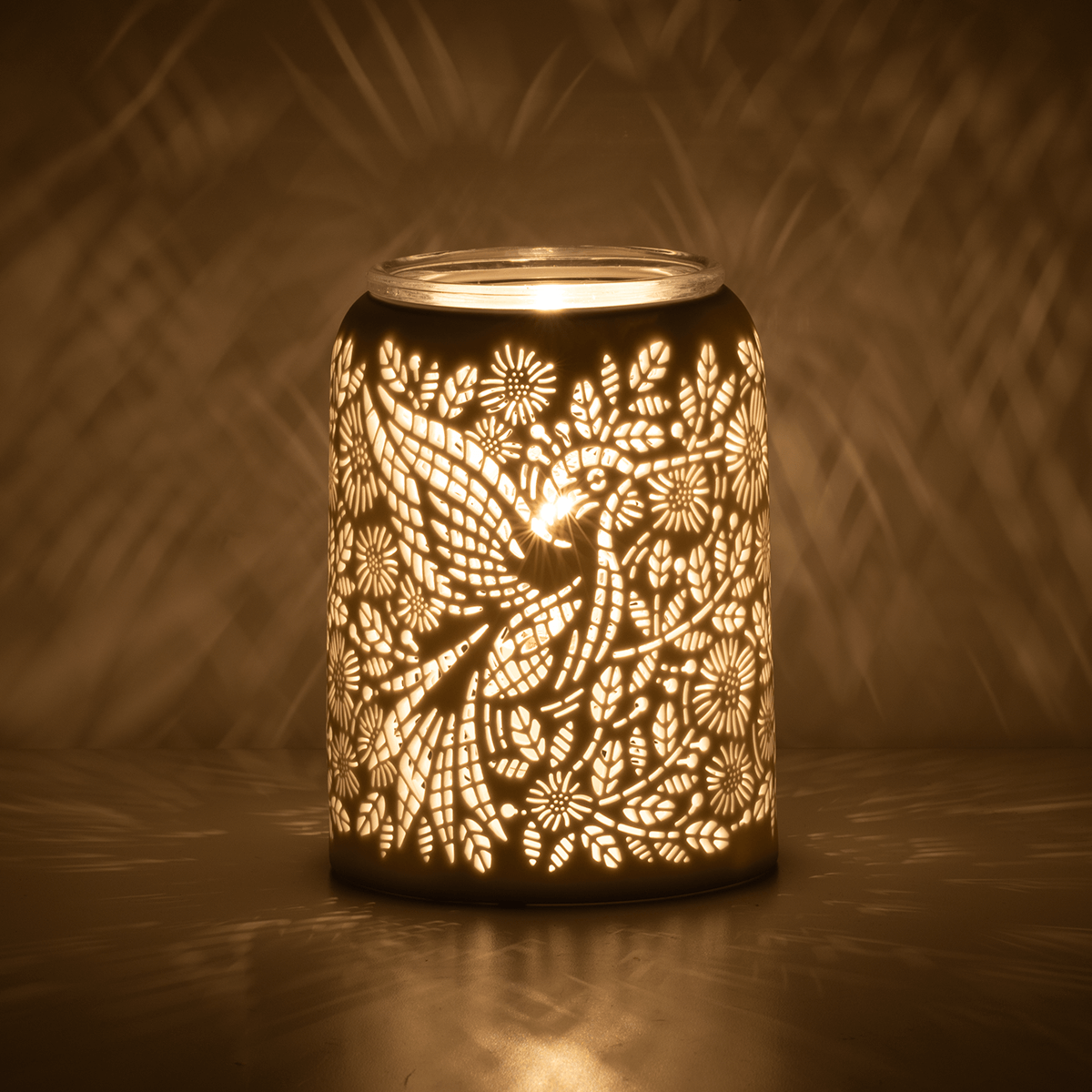 Etched Hummingbird Scentsy Warmer glowing in a dark room