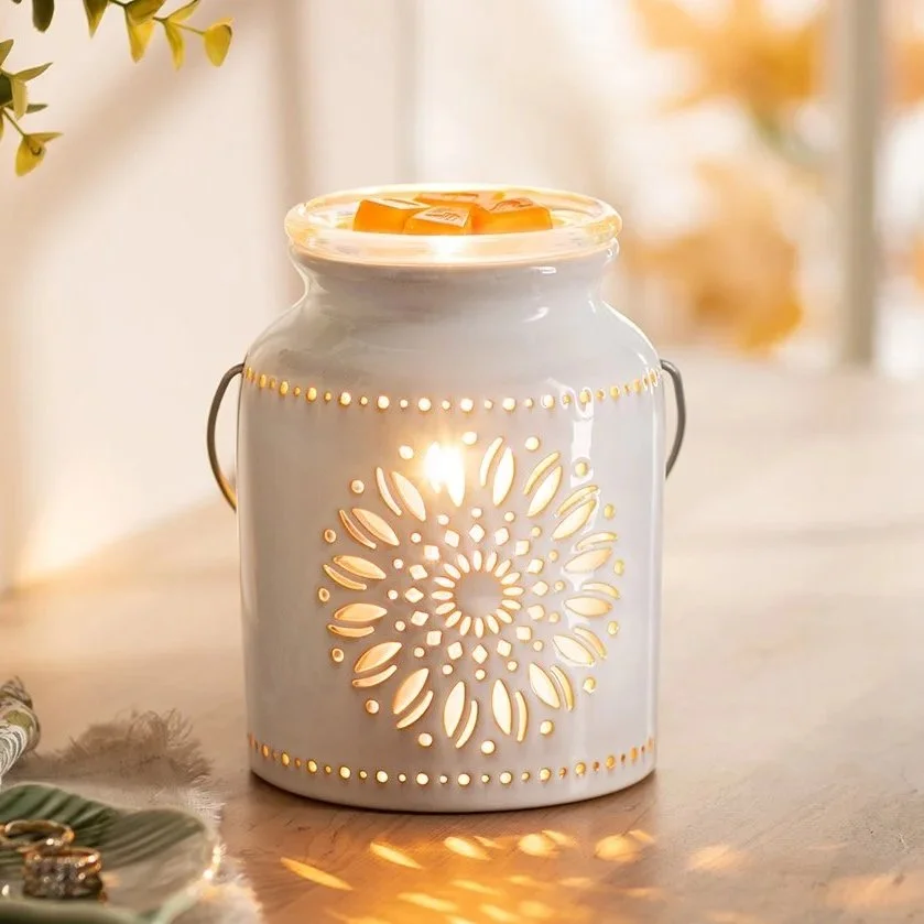 The Heirloom Flower Scentsy warmer glows softly as it rests on a styled table, highlighting its delicate floral design and adding an elegant, timeless warmth to the space.