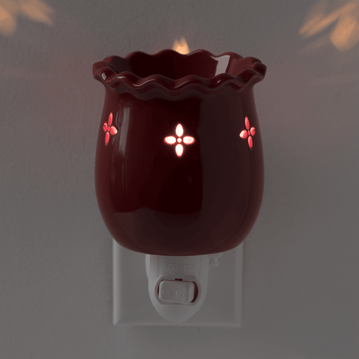 Laurel Red Mini Scentsy Warmer lit in low light with warm glow shining through vintage-style cutouts