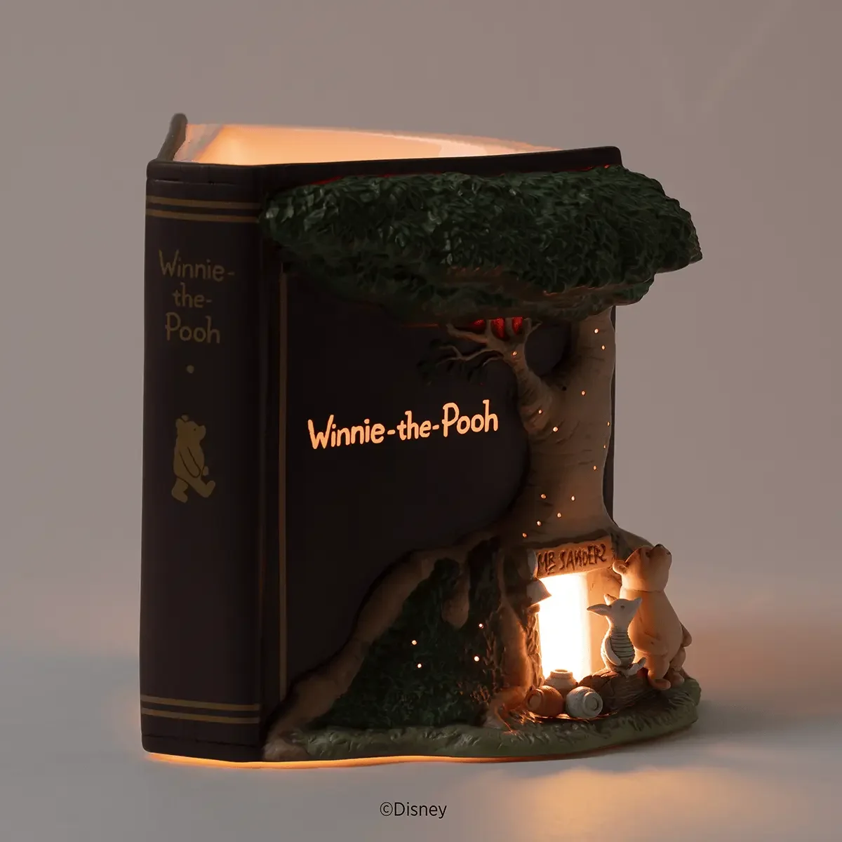 Disney Winnie the Pooh 100 Years of Friendship Scentsy Warmer glowing in a dimly lit setting, highlighting Pooh and Piglet outside the illuminated doorway.