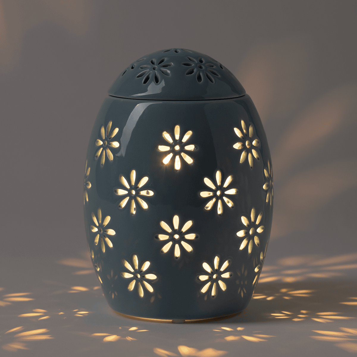 Easter Garden – Blue Scentsy Warmer illuminated in a darker room, casting a warm floral glow