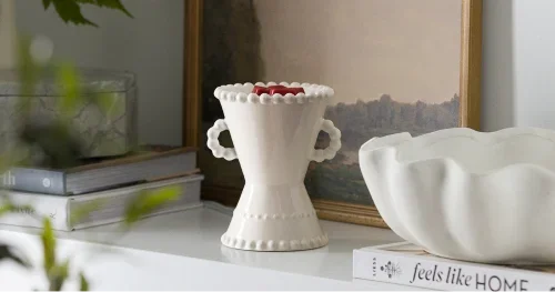 White decorative Scentsy wax warmer displayed on a shelf with elegant home décor
