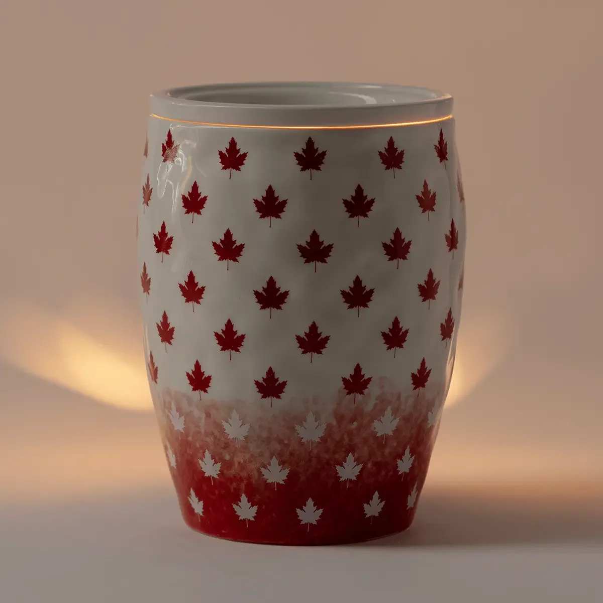 Simply Maple Scentsy Warmer illuminated, featuring red maple leaf details and a warm glow through its glossy ceramic finish