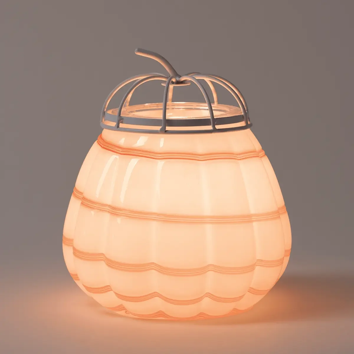 Cider Swirl Pumpkin Scentsy Warmer illuminated against a dark background