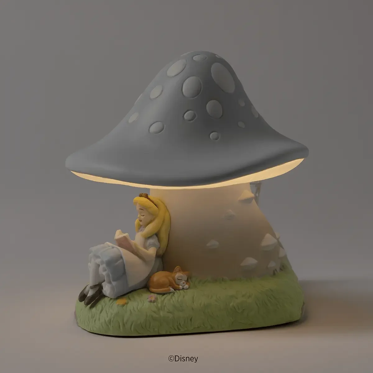 Disney Alice in Wonderland Scentsy Warmer glowing warmly in a darkened setting with Alice and Dinah