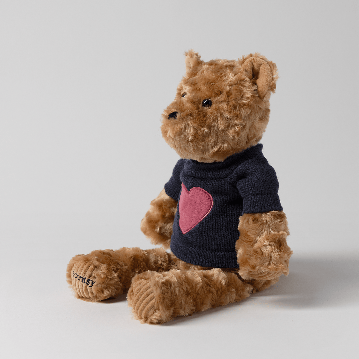 Side view of Banner the Bear Scentsy Buddy showing the soft plush teddy bear and removable navy heart sweater