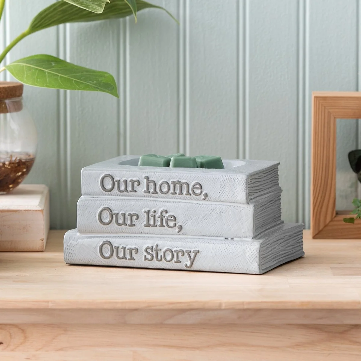 Our Story Scentsy Warmer styled in a bright reading nook with wax in the dish