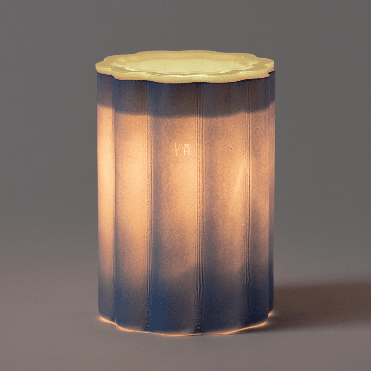 Vibrant blue Bloomie wax warmer from Scentsy, designed to add bold personality and artistic flair to any space in a dark room glowing