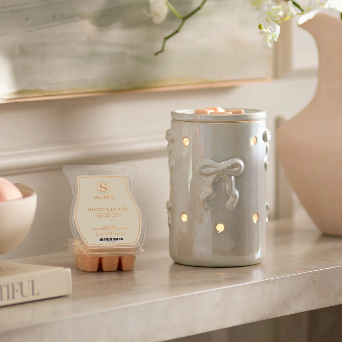 Dreamer’s Bow Scentsy Warmer with pearlized finish and delicate bow design with a peach & Amber wax bar styled