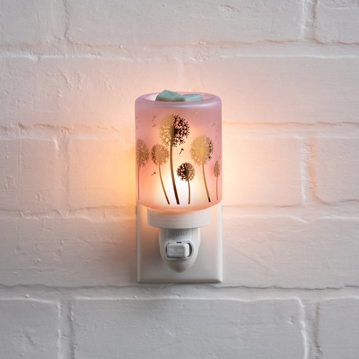 A decorative Scentsy mini warmer featuring a delicate dandelion-inspired design, created to add soft light and gentle fragrance to smaller spaces while providing a safe, flame-free way to enjoy wax.