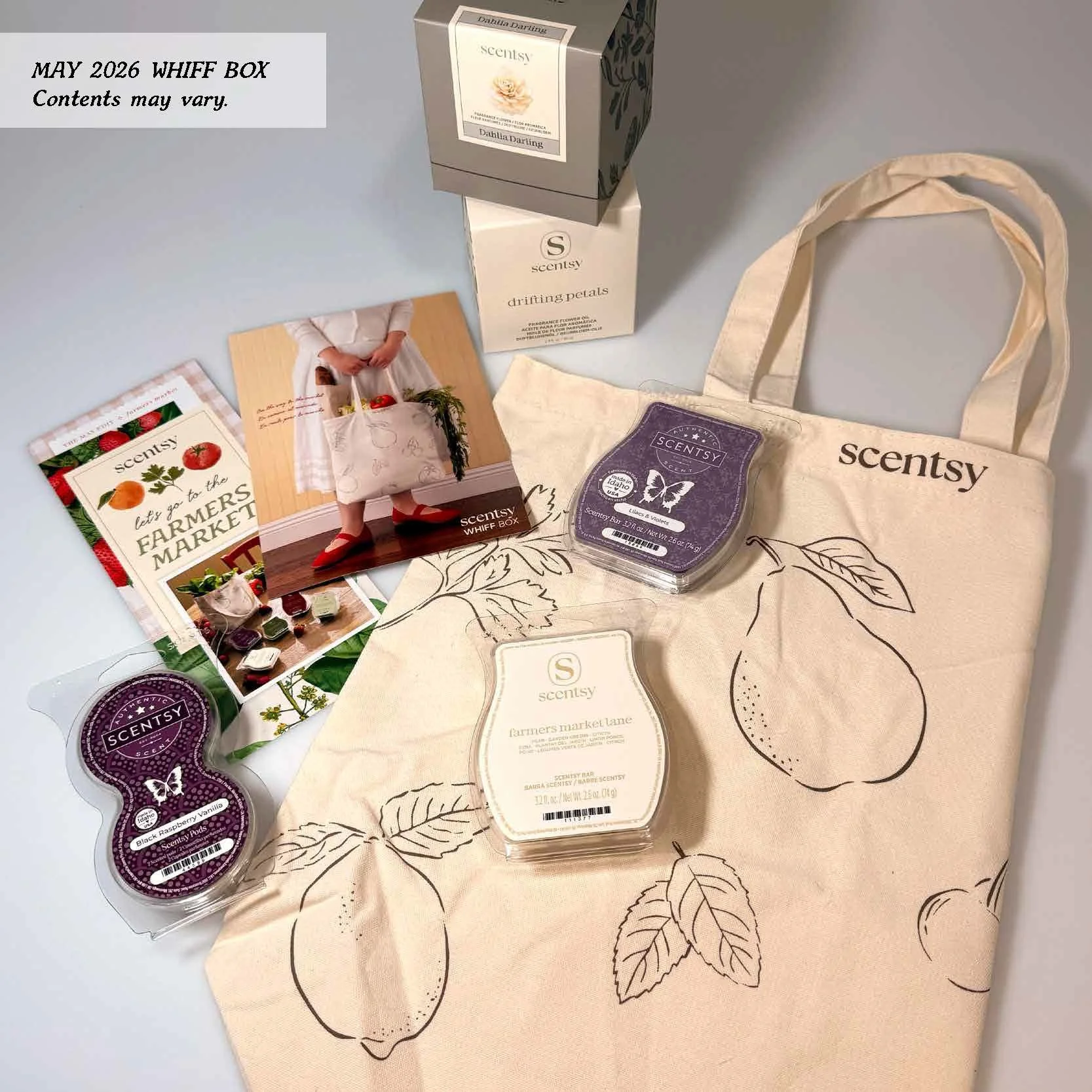 Scentsy May 2026 Whiff Box featuring a farmers market theme with a canvas tote, Scentsy wax bars, fragrance products and promotional materials styled on a neutral background.