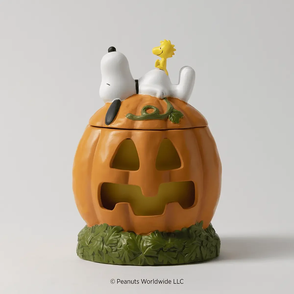 Snoopy's Pumpkin Patch Scentsy Warmer featuring Snoopy and Woodstock resting on top of an orange jack-o'-lantern with a green leafy base.