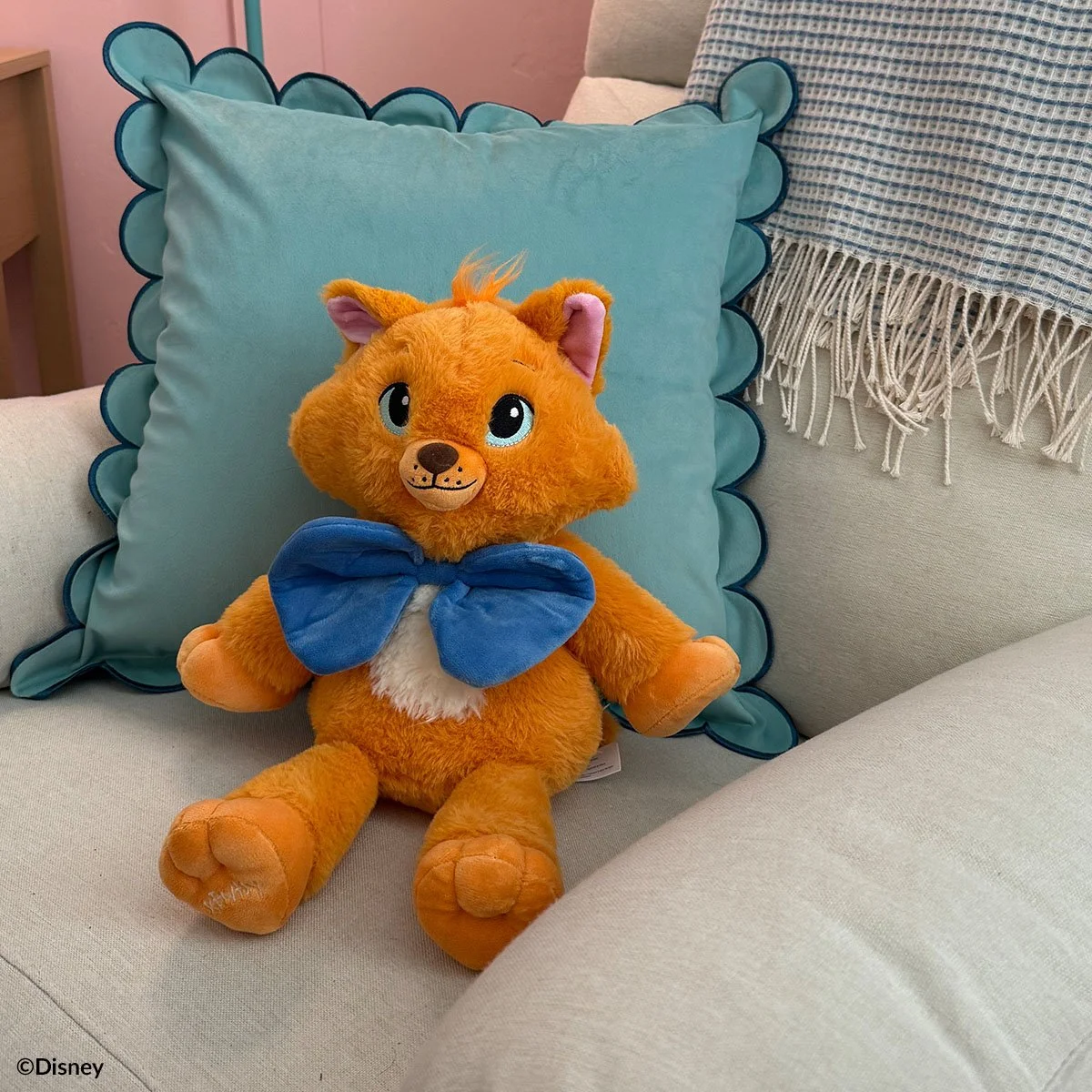 Disney Toulouse Scentsy Buddy plush inspired by The Aristocats styled on a couch with a pillow