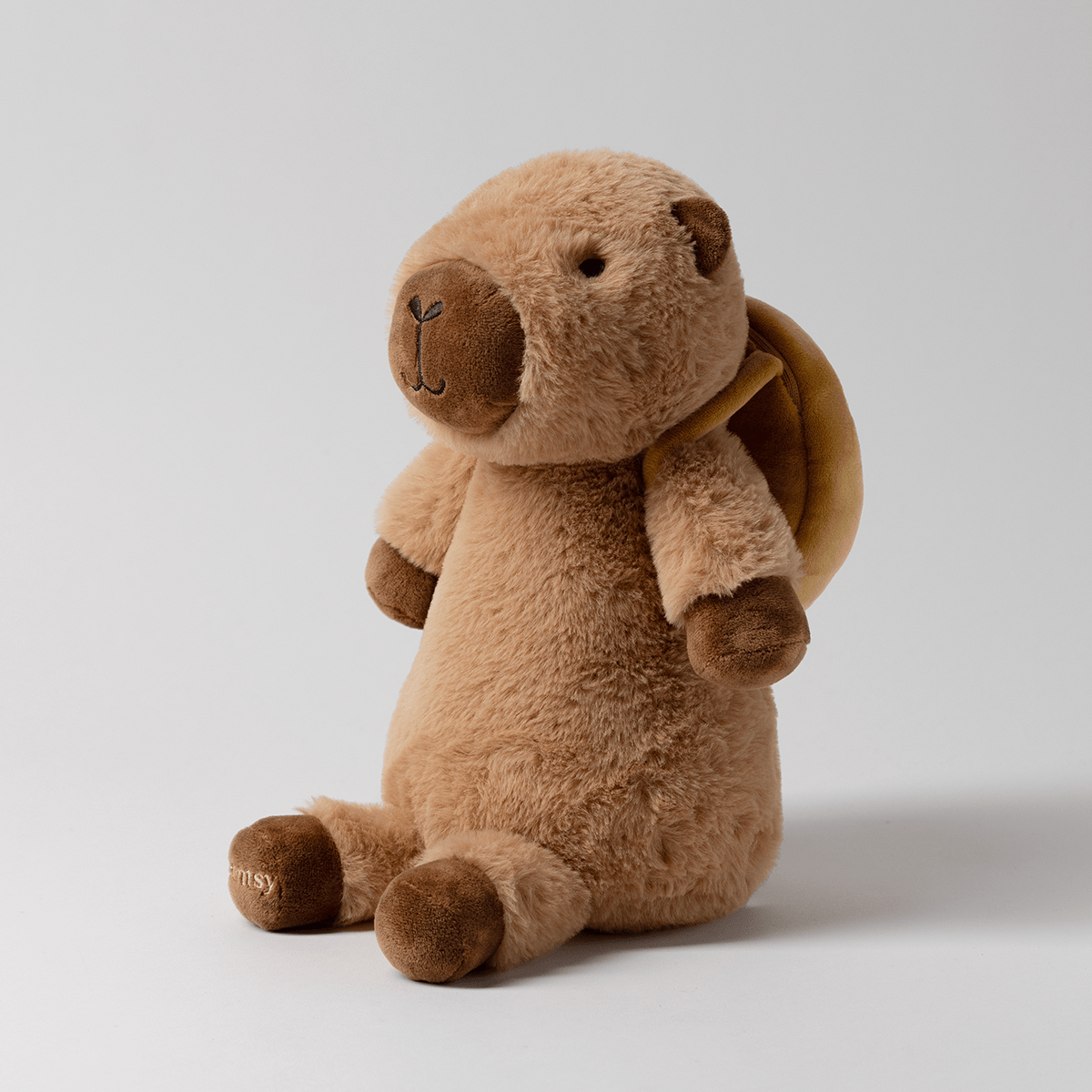 Side view of Crumb the Capybara Scentsy Buddy showing the donut-shaped backpack