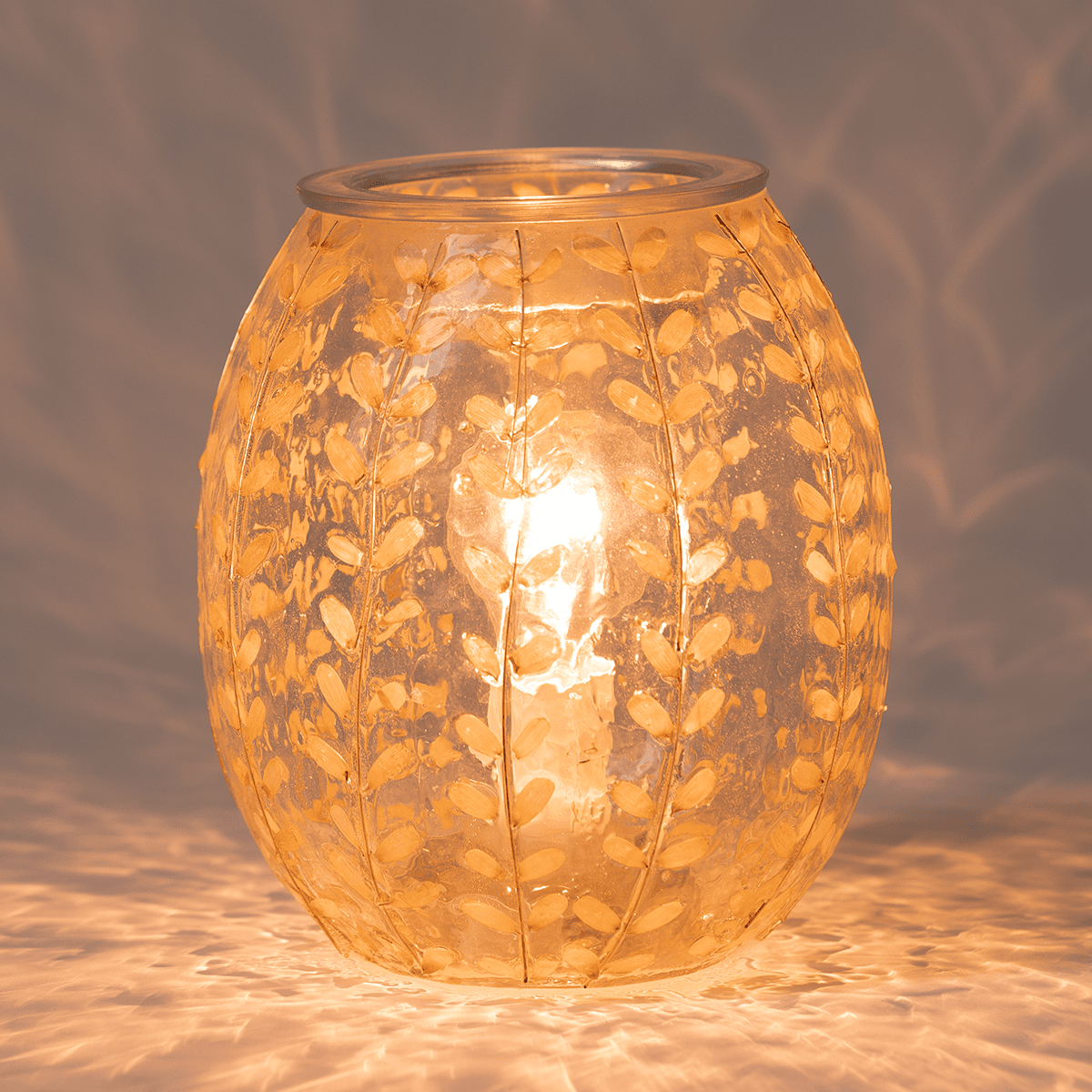 White Marigold Scentsy Warmer glowing brightly in a dark setting with warm golden light shining through real petals