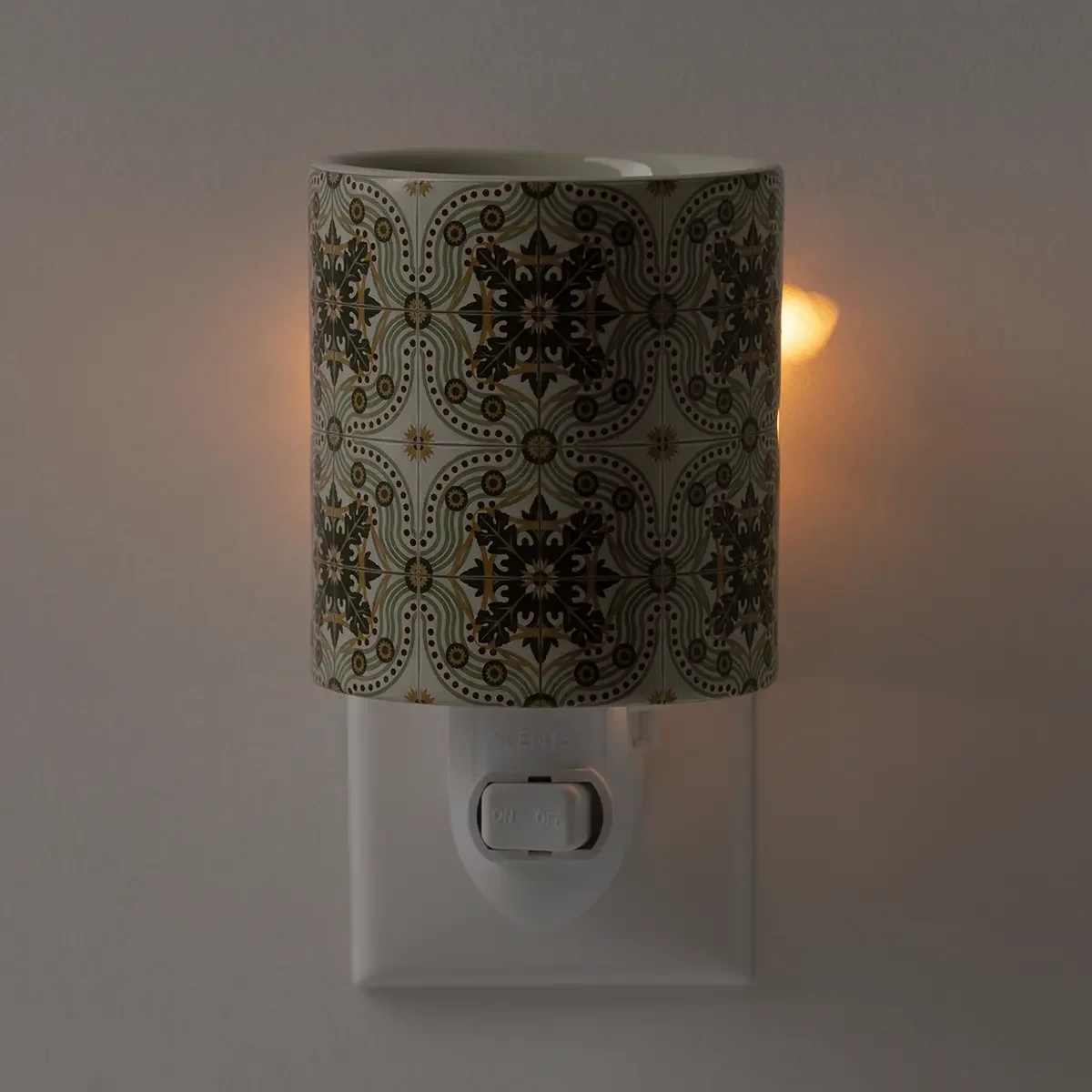 Terrazza Tile Mini Scentsy Warmer glowing while warming wax, showcasing its intricate Italian ceramic tile pattern and warm ambient light