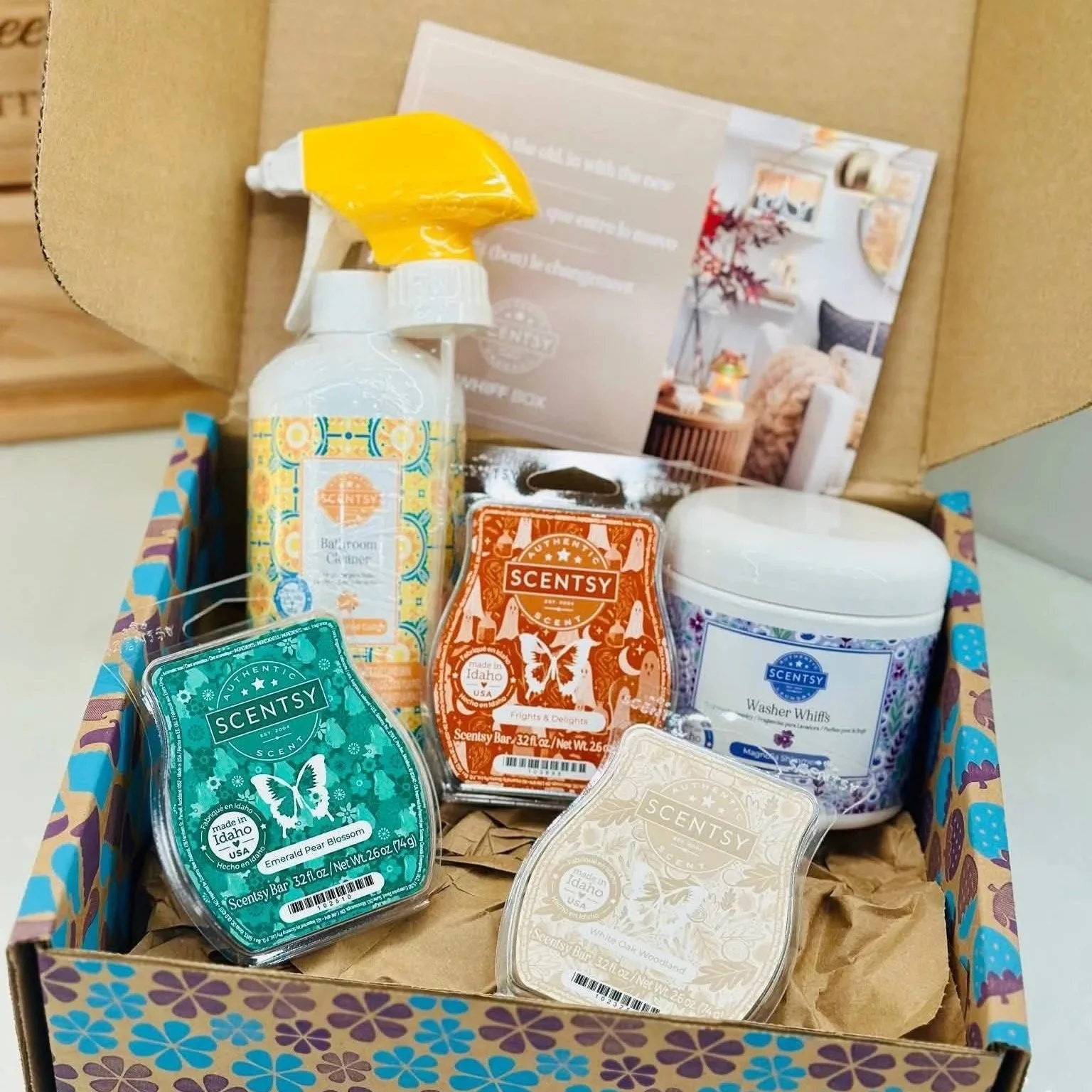 Open Scentsy Whiff Box featuring Scentsy Bars, counter cleaner, laundry products, and monthly surprise items