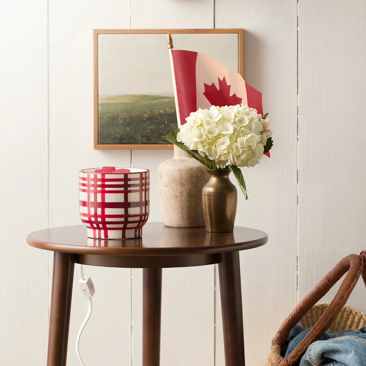 The Canadian Plaid Scentsy Warmer features a bold red and white plaid design that captures the warmth and charm of classic Canadian décor. Styled with a Canadian flag and farmhouse-inspired accents, it adds a cozy, nostalgic feel to any space