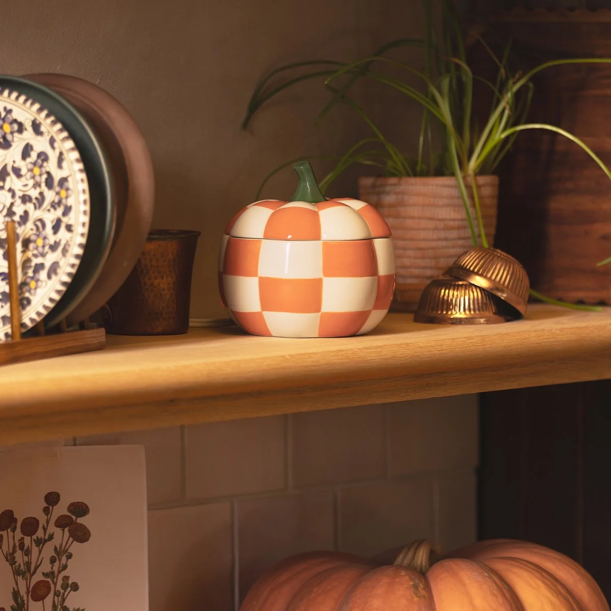 Scentsy Patchwork Pumpkin Warmer styled on a shelf with warm autumn décor and harvest-inspired accents. 4. Pumpkin Posy Mini Warmer File name: scentsy-pumpkin-posy-mini-warmer-harvest-collection.jpg Alt text: Scentsy Pumpkin Posy Mini Warmer glowing 