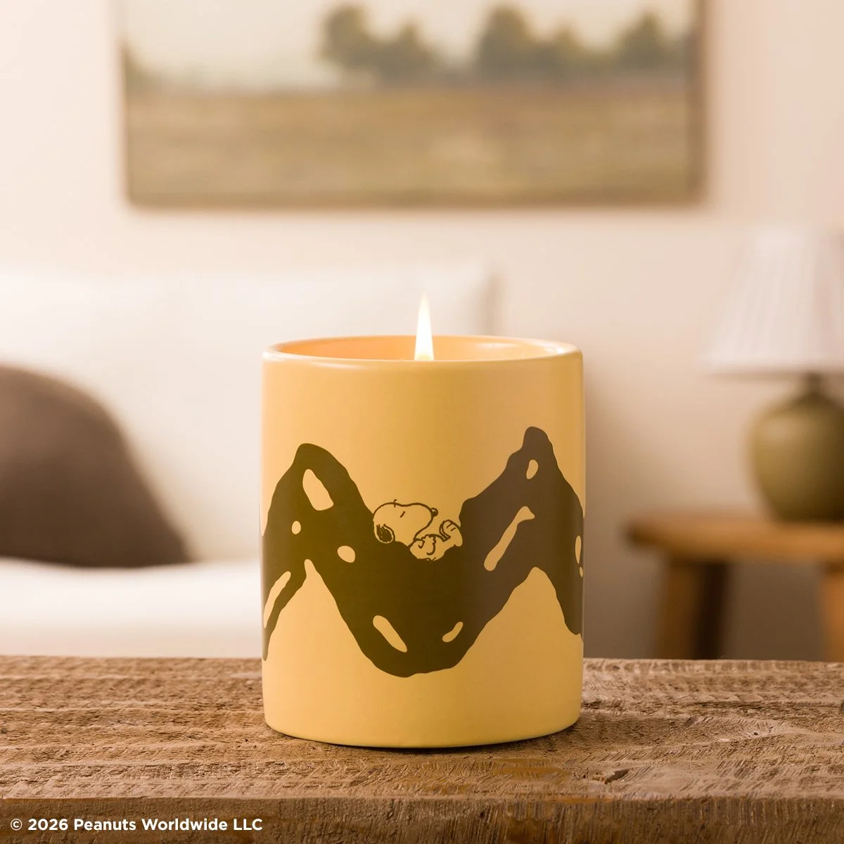 Peanuts Good Grief scented candle featuring Snoopy resting between mountain silhouettes