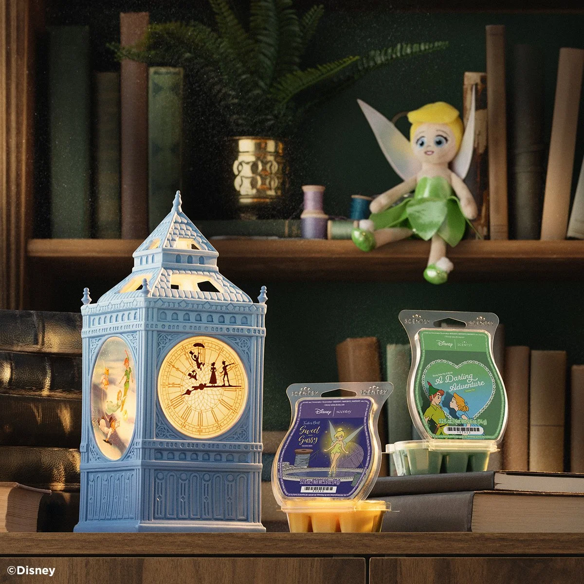 Disney Peter Pan Scentsy collection featuring Flight to Neverland warmer, Tinker Bell and Scentsy wax bars on a bookshelf