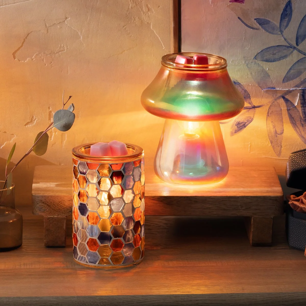 The Amanita and Golden Oak Scentsy Warmers are styled together to showcase glowing glass textures and rich color, creating a bold and artistic enliven decor moment.