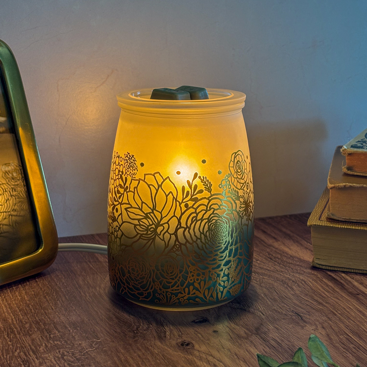 Tranquil Glow Scentsy Warmer on a tabletop casting a calming green glow