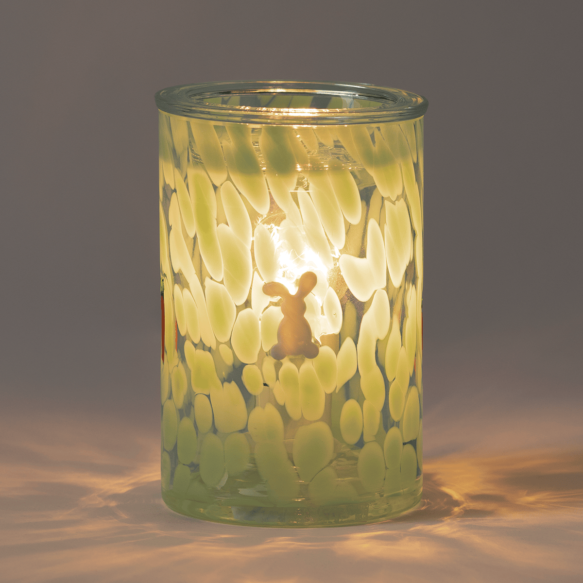 Verdant Escape Scentsy Warmer illuminated in a dim room, casting a verdant green glow