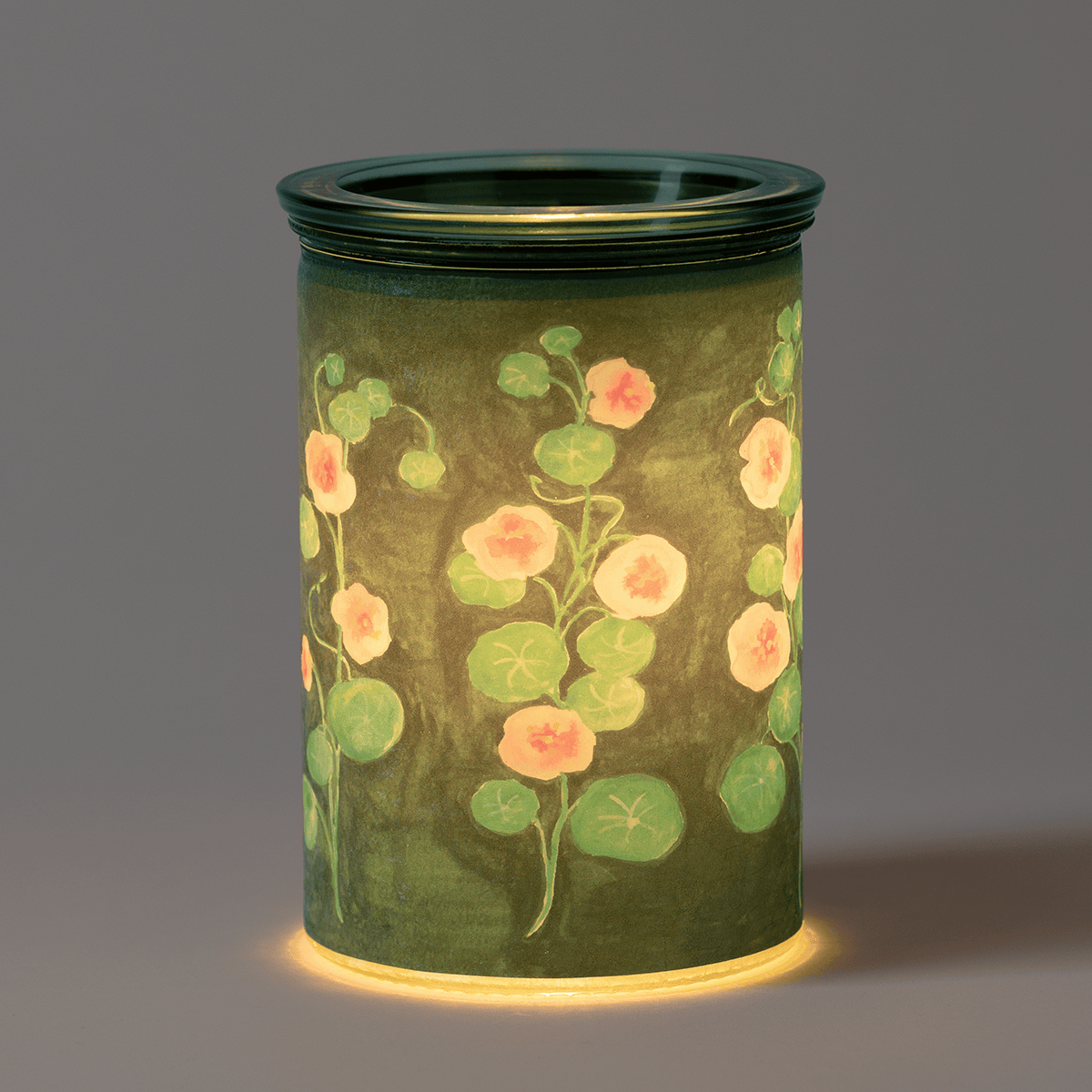 Garden Whimsy Scentsy Warmer in a dark room glowing