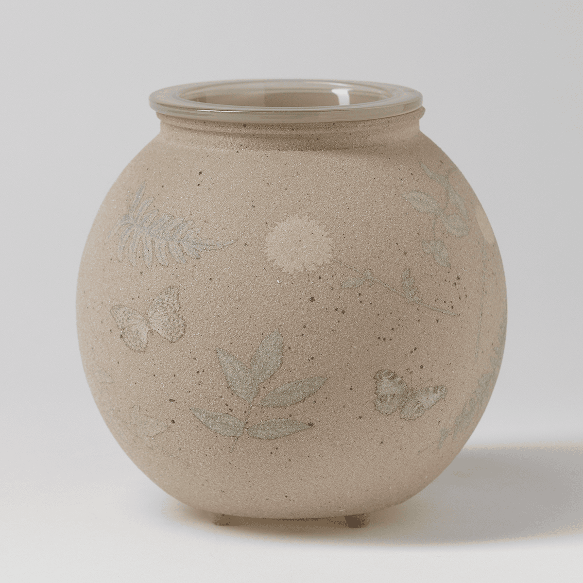 Even unlit, the Veiled Meadow Warmer showcases its soft, neutral tone and textured sanded glass design
