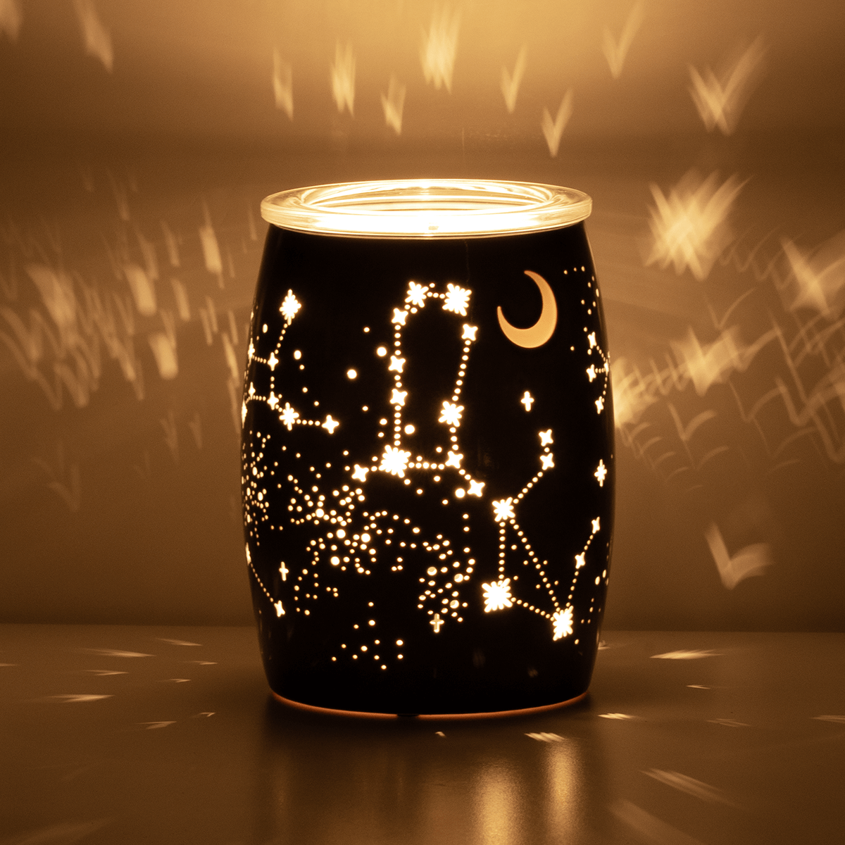 Constellations Scentsy Warmer projecting light patterns in a dark room