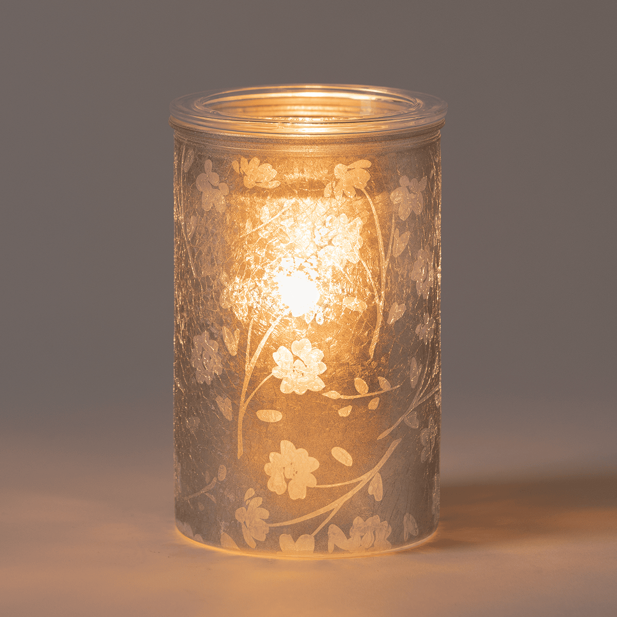 Silver Stem Scentsy warmer glowing in a dim room with delicate light patterns