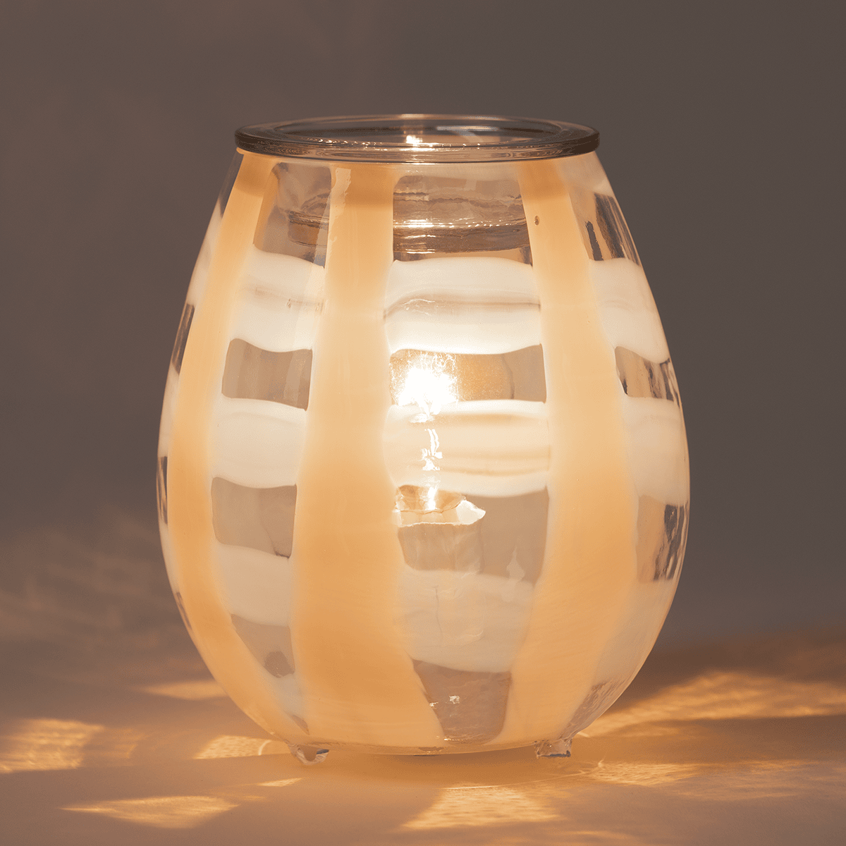 Lightweave Scentsy warmer glowing in a dark room with warm ambient patterns