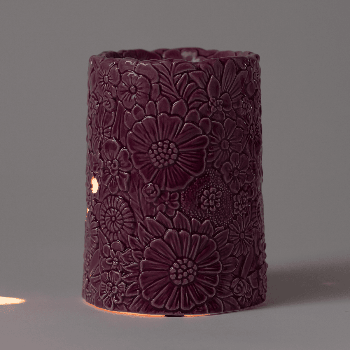 Dusky Petals Scentsy Warmer glowing warmly in a low-light setting with subtle light at the base