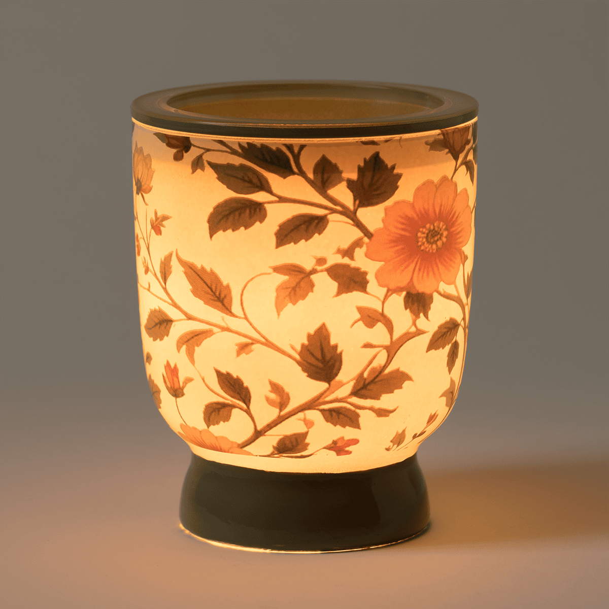 Petal & Vine Scentsy warmer glowing warmly with vintage floral design in a dark room