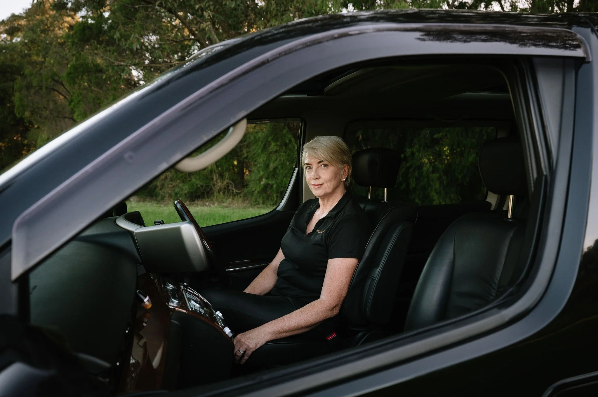 Tracie at the steering wheel inside the luxurious ElGrand Highway Star people mover