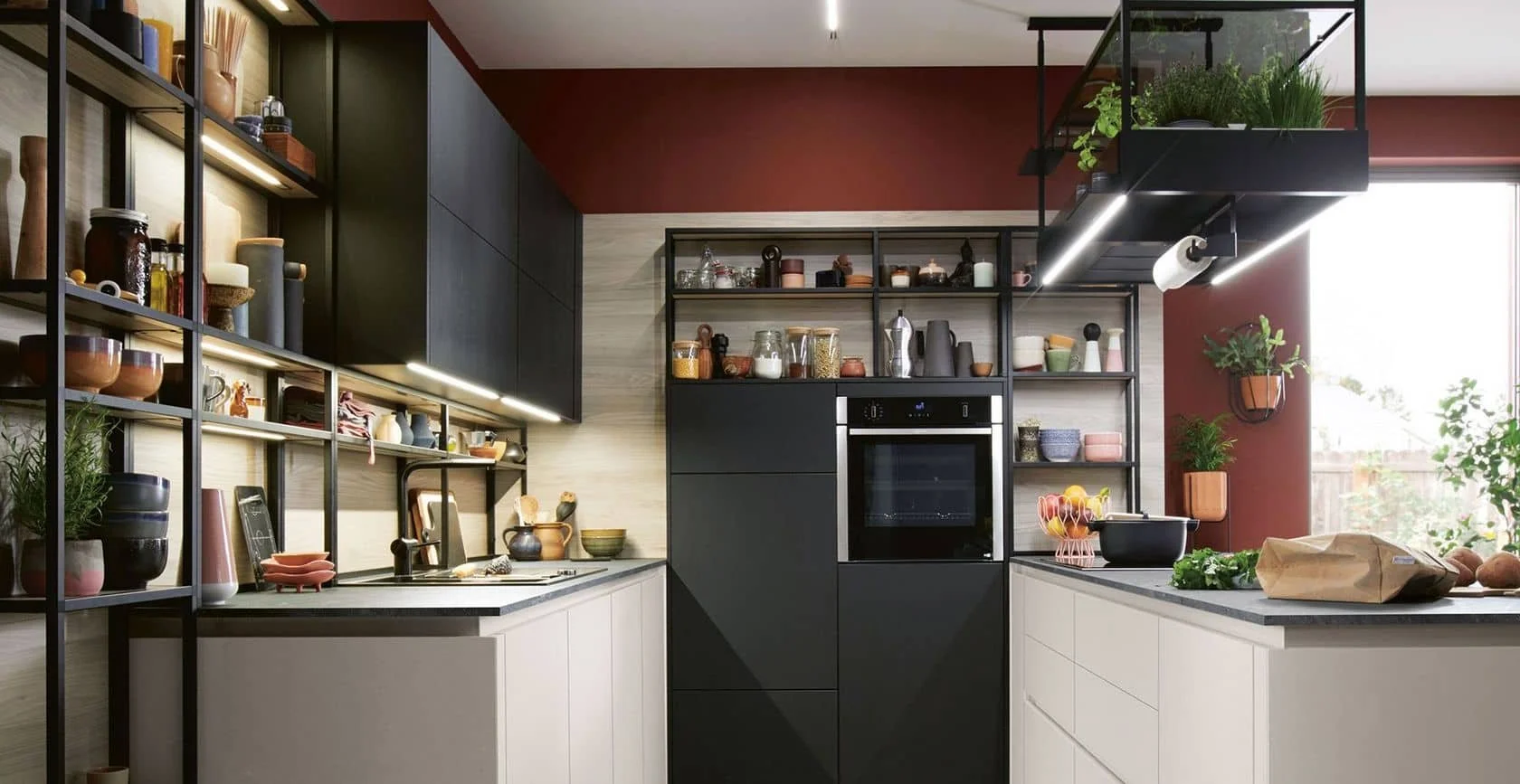 Modern kitchen with black and white cabinetry, open shelving, and plants, featuring built-in appliances and a large window with natural light.