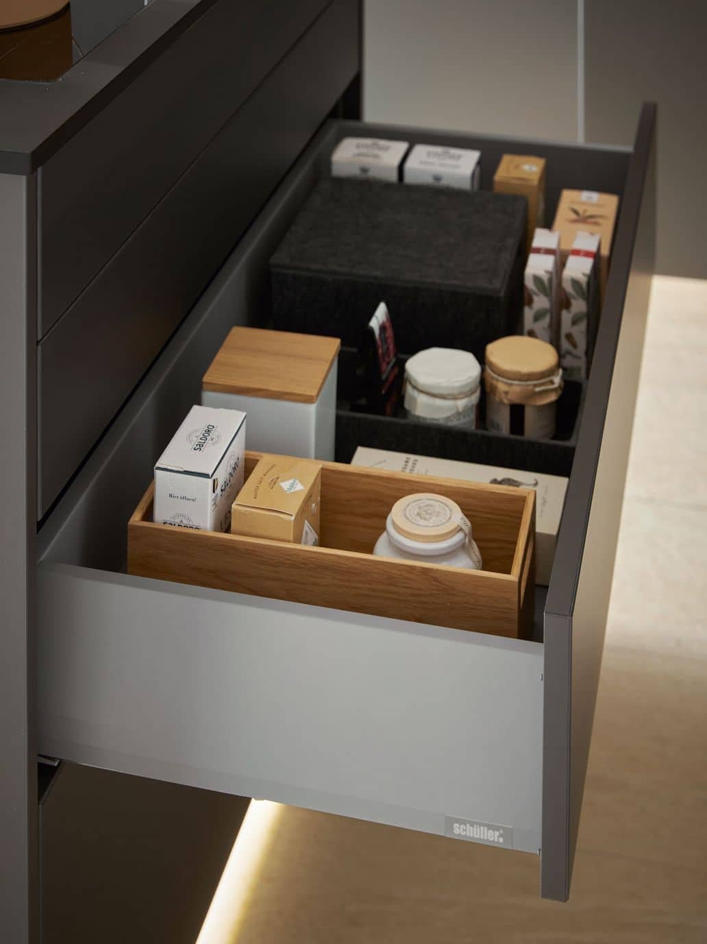Drawer containing various coffee and tea products, including boxes, tins, and jars.