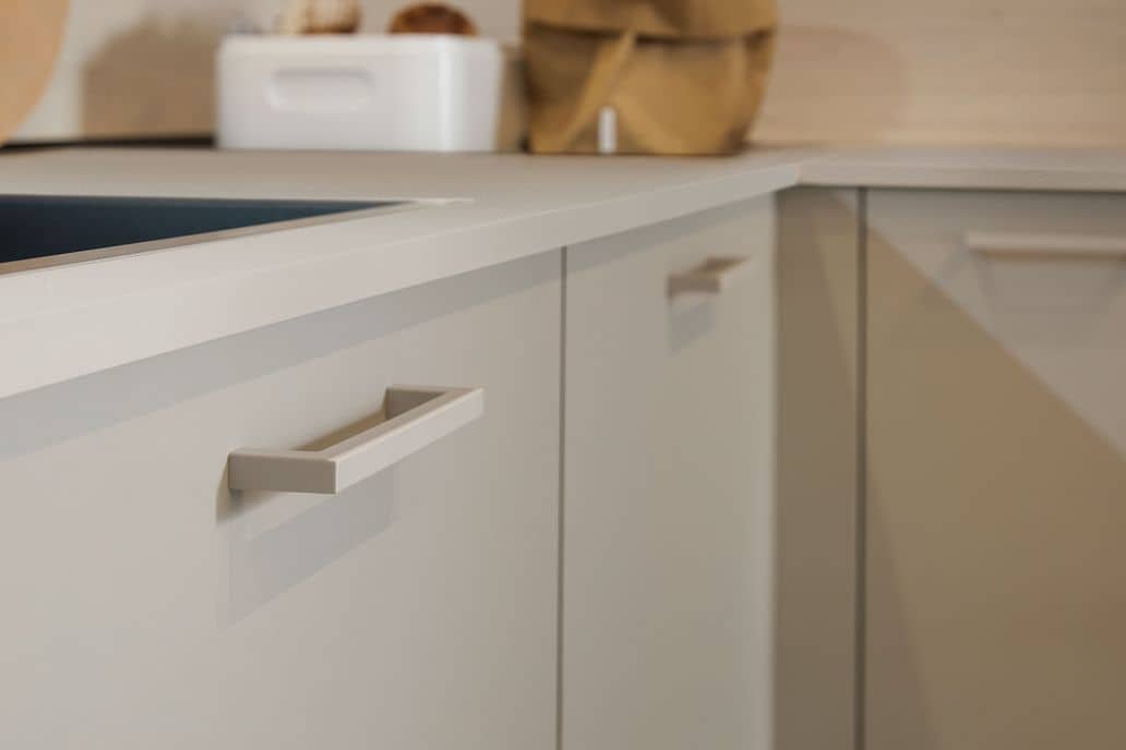 Close-up of a modern white kitchen cabinet drawer with a sleek handle.