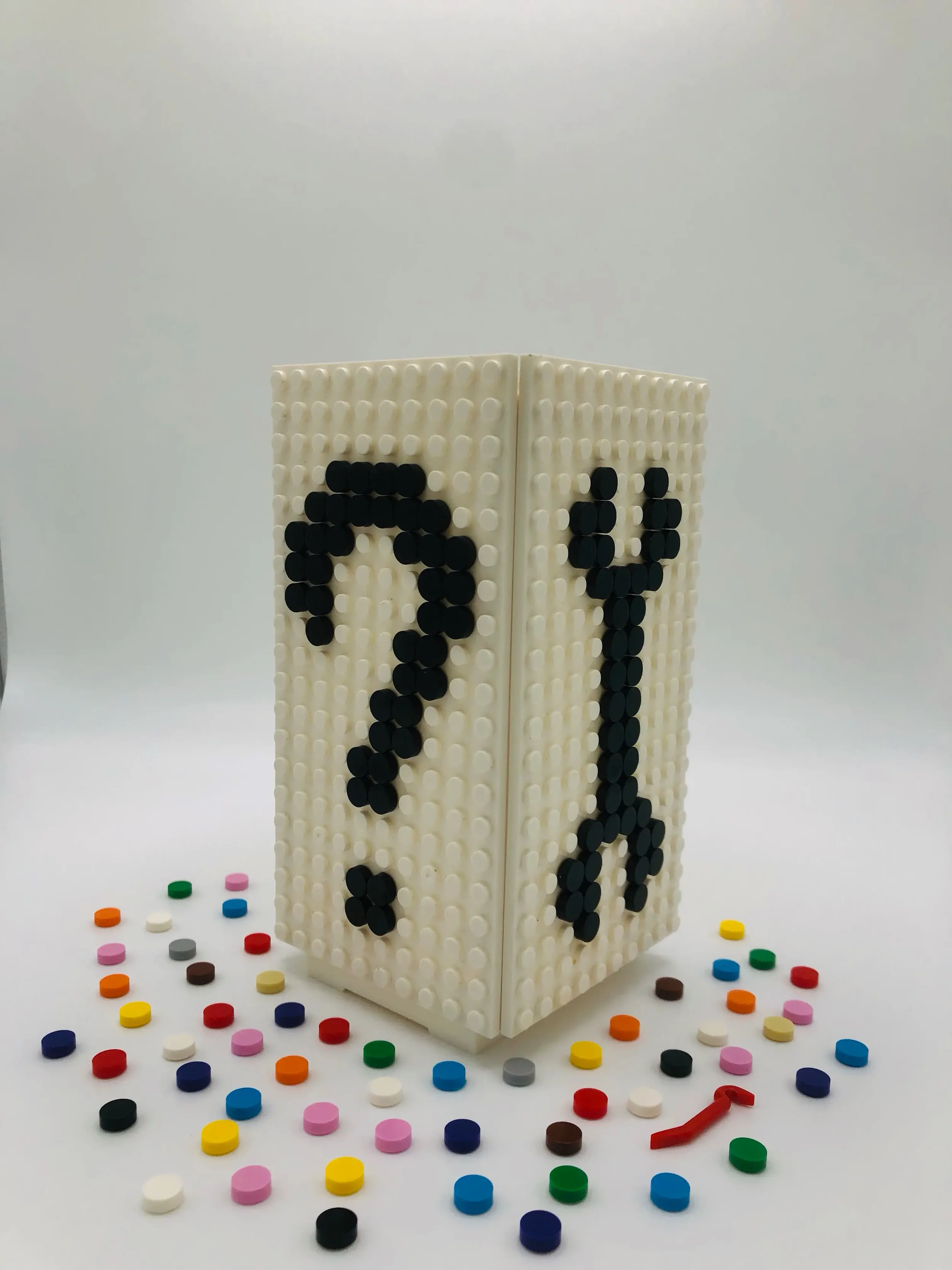 A Jaim mood lamp featuring a pixel art question mark design, displayed with a wrench tool and colorful building dots to represent the manual, hands-on assembly experience.