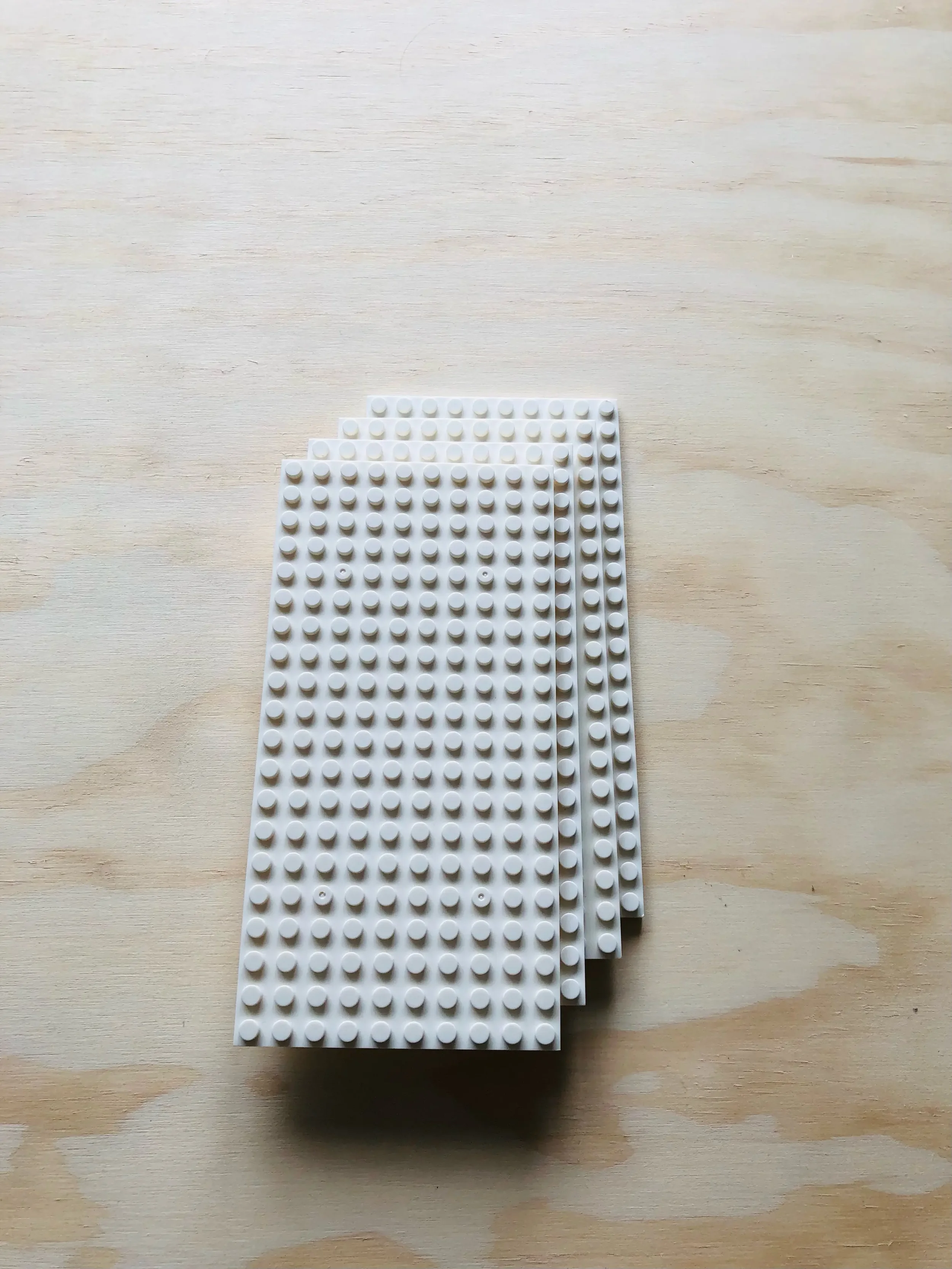 A stack of four durable 10x20 building block grid panels. Spare parts and extra canvas plates for the Jaim customizable LED nightlight.