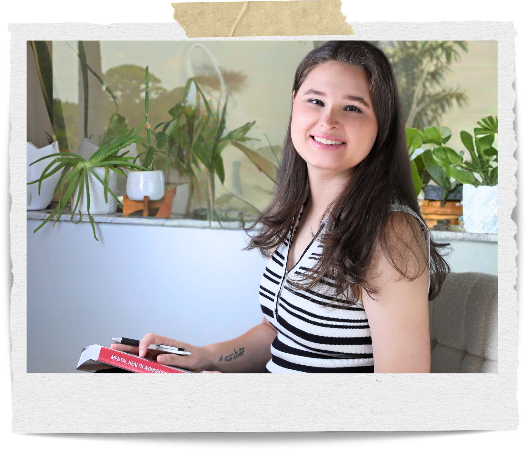 A young woman with long dark hair smiling and sitting on a beige couch inside a room decorated with various green potted plants on a white shelf and windowsill.