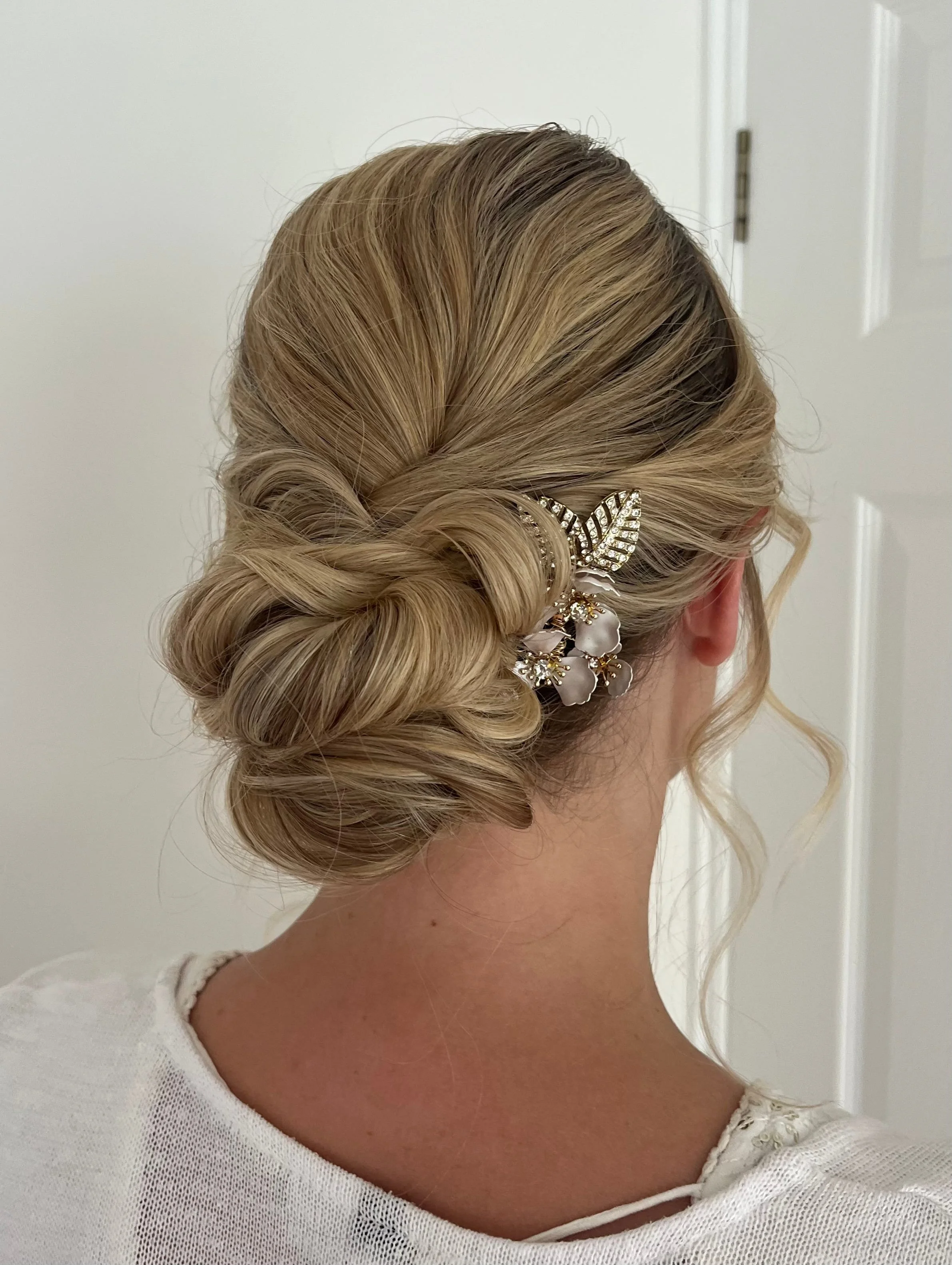 A soft, textured low bridal hair up idea created on blonde hair.