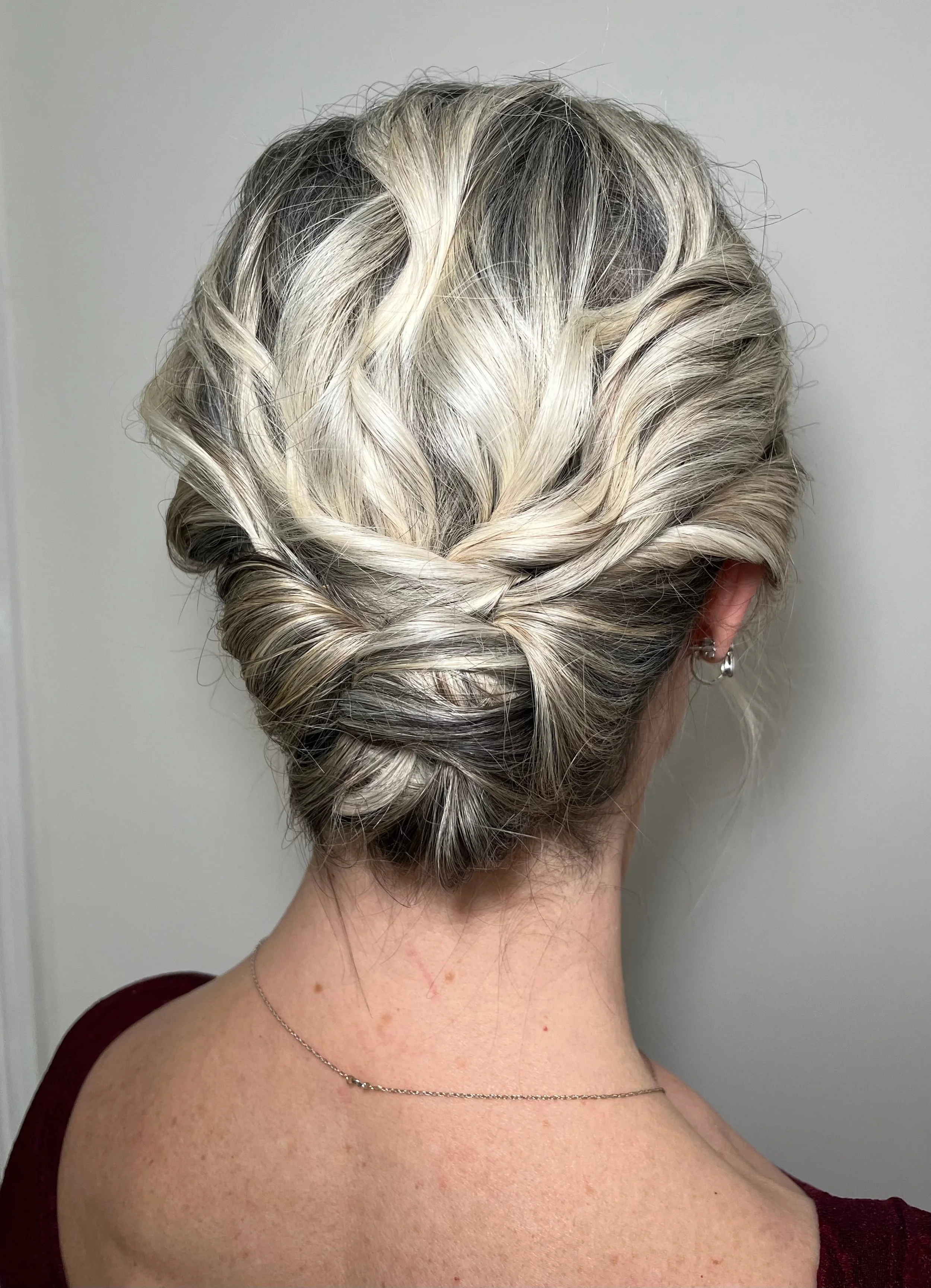 A textured bridal updo hairstyle created on short, blonde hair.