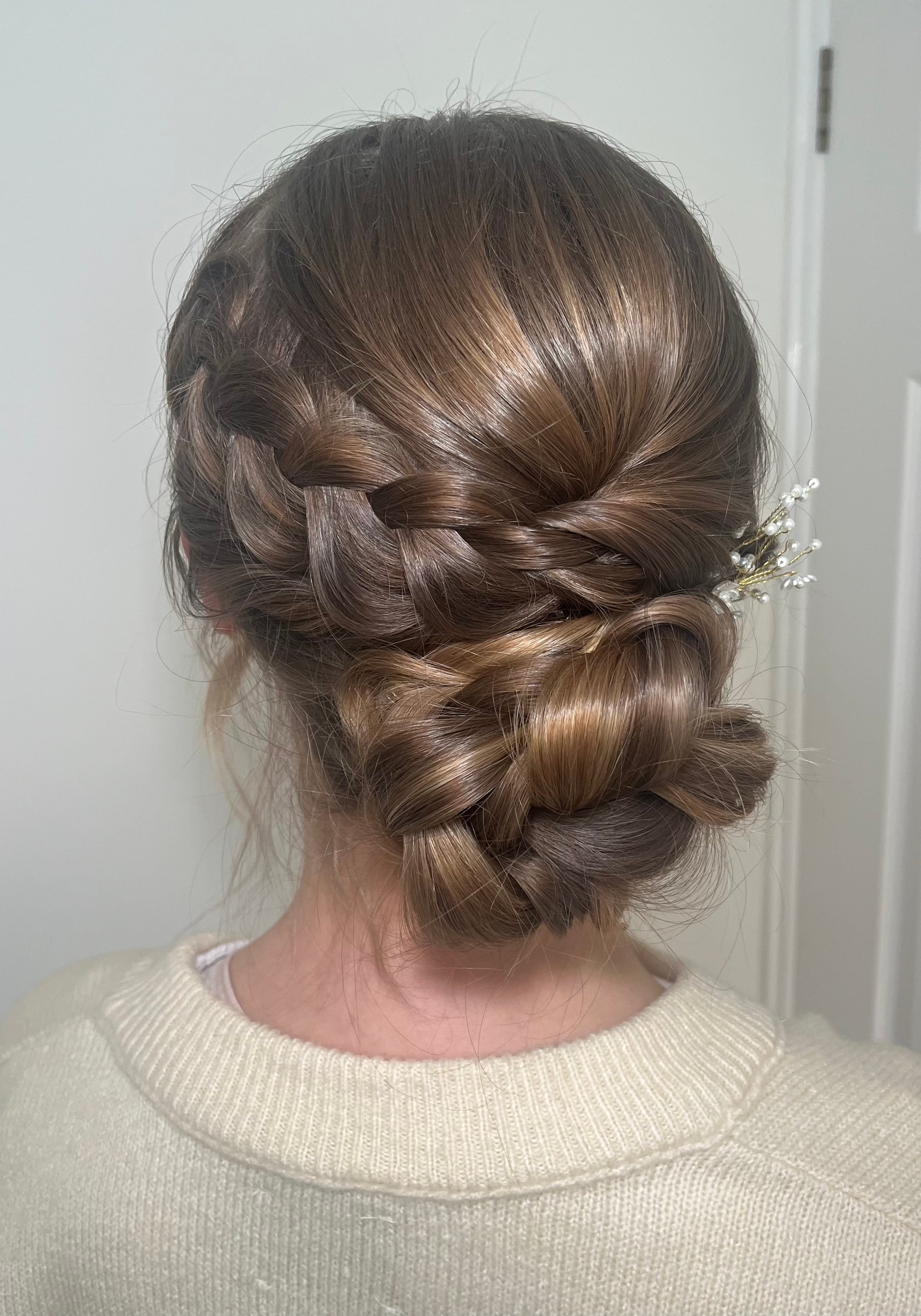 A braided low bun bridal updo hair style created on dark blonde hair.