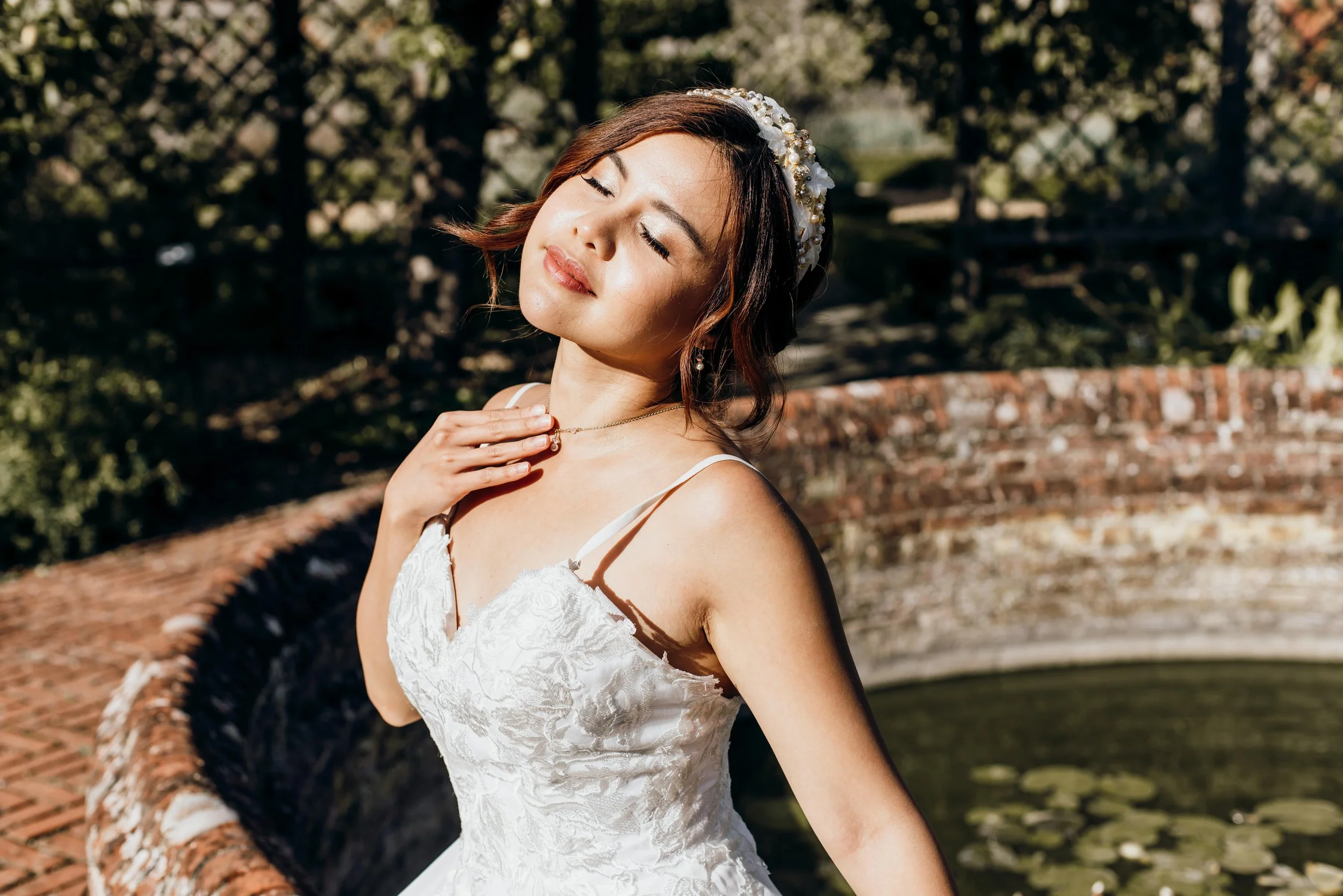 A bride sitting in the sun after having her hair and makeup done for her wedding day at Cressing Temple Barns in Essex.